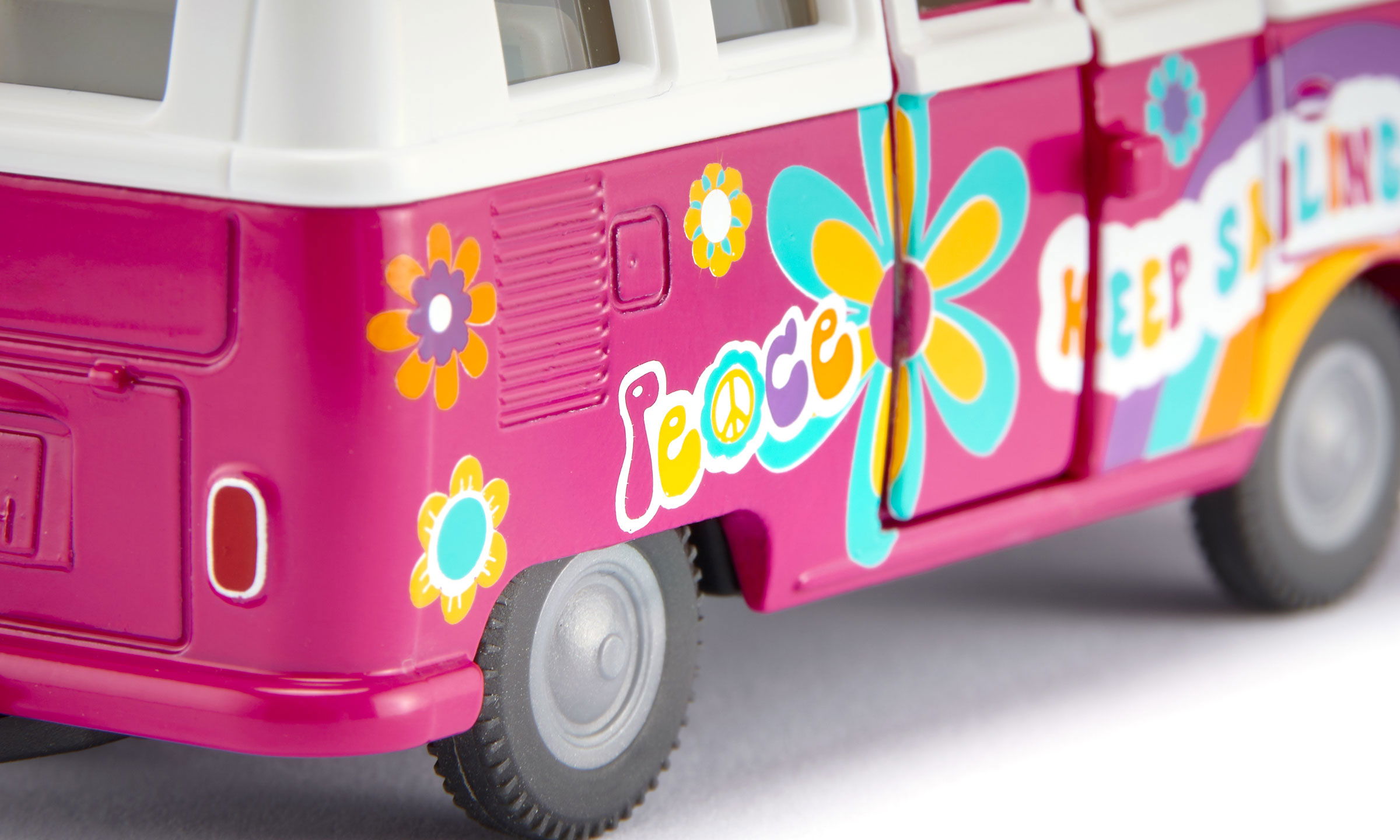 siku VW T1 Samba in pink  und weißem Dach mit bunten Blumen. Bedruckung Love und Stay Groovy in bunter Schrift.  Detailansicht 