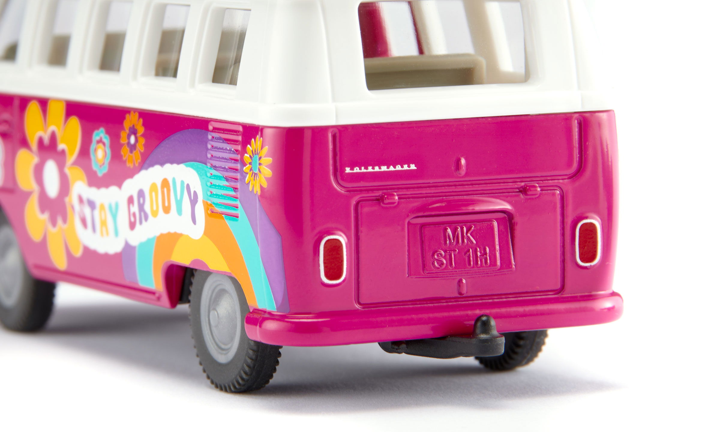 siku VW T1 Samba in pink  und weißem Dach mit bunten Blumen. Bedruckung Love und Stay Groovy in bunter Schrift.  Schräg  von hinten fotografiert